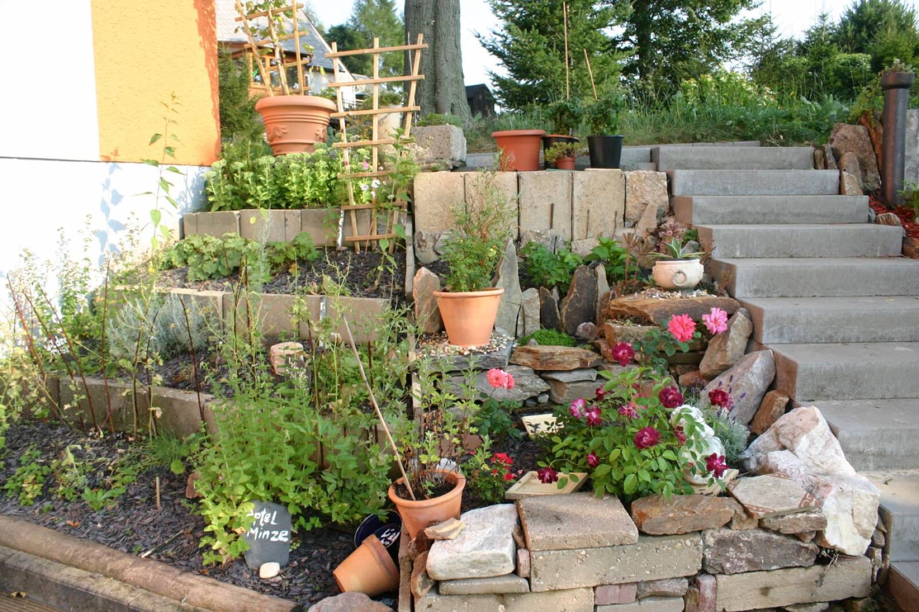 Kräutergarten des Gasthofs mit Trockenmauern und Steintreppe